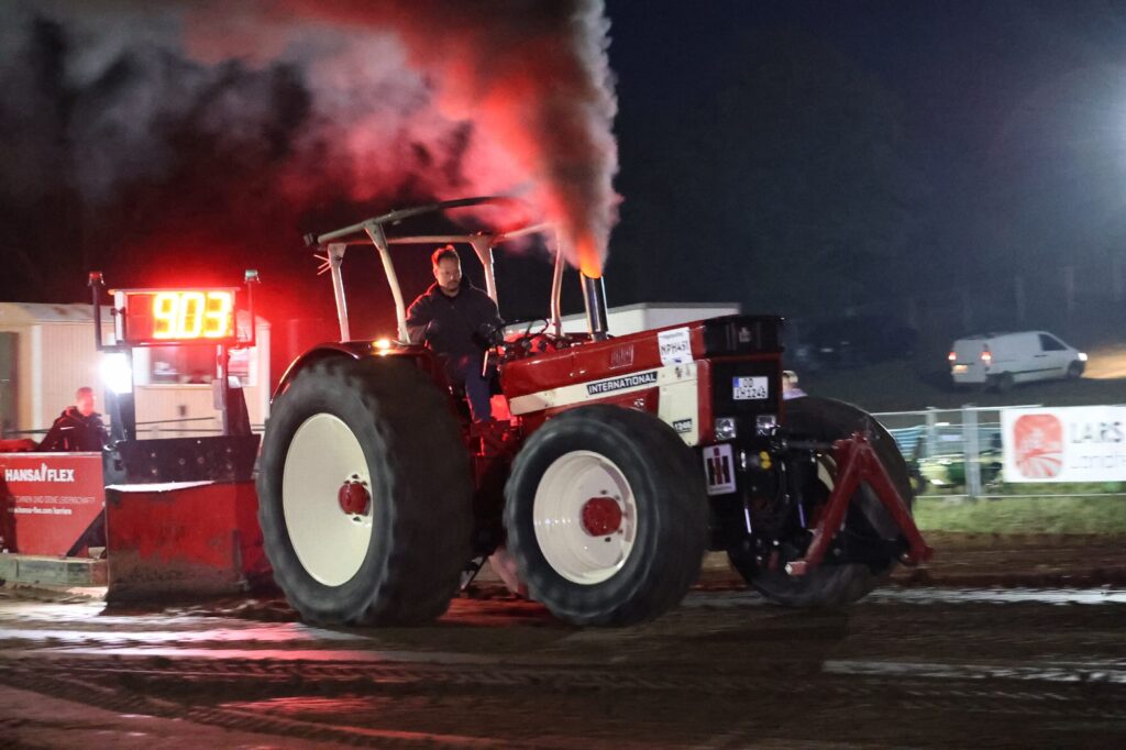Roter Trecker beim Nightpulling in der Abenddämmerung