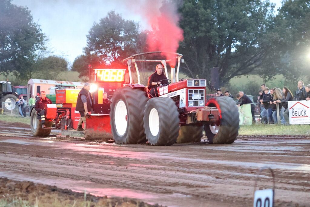 Trecker mit rot leuchtender Rauchfahne am Nachmittag